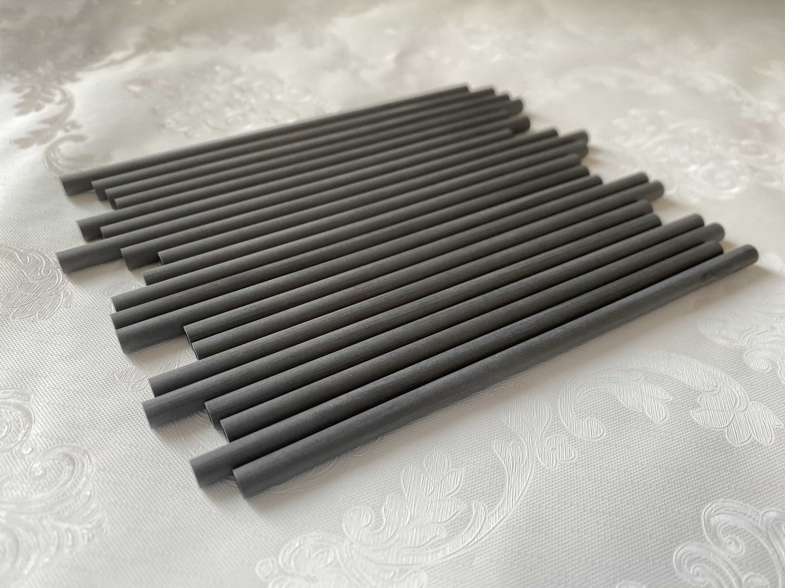 alt="engineer inspecting carbon fiber tube for quality"